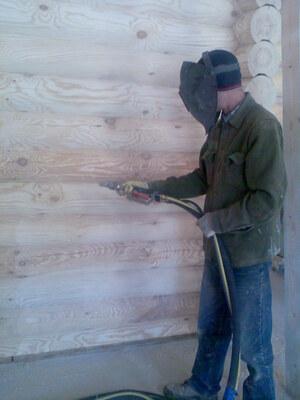 Sandblasting cleaning of a wooden log house